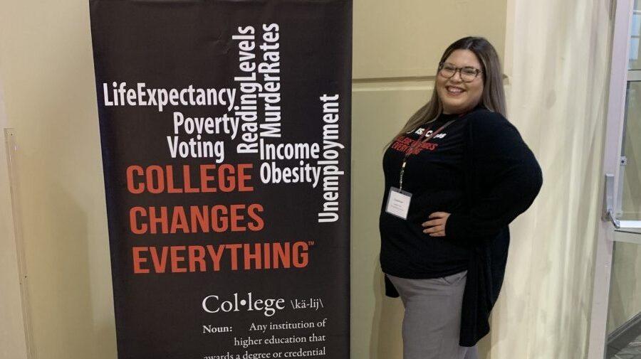 young person next to a black sign with words on it